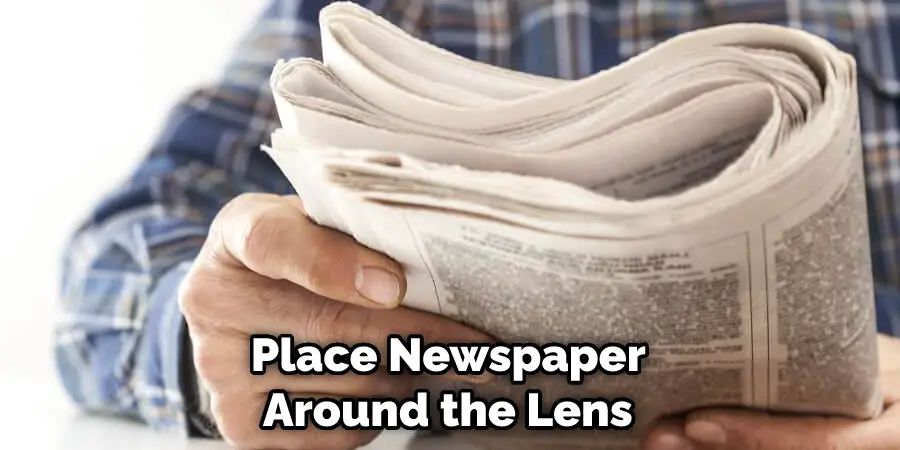 Place Newspaper Around the Lens 